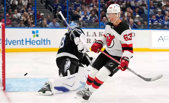 New Jersey Devils left wing Jesper Bratt (63) reacts after scoring a shorthanded goal past Tampa Bay Lightning goaltender Andrei Vasilevskiy (88) during the third period of an NHL hockey game Saturday, Oct. 11, 2025, in Tampa, Fla. (AP Photo/Chris O'Meara)