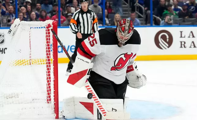 New Jersey Devils goaltender Jacob Markstrom (25) makes a save on a shot by the Tampa Bay Lightning during the second period of an NHL hockey game Saturday, Oct. 11, 2025, in Tampa, Fla. (AP Photo/Chris O'Meara)