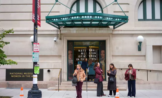 People are seen waiting outside the main entrance of the National Museum of Women in the Arts in downtown Washington, Wednesday, Oct. 29, 2025. (AP Photo/Pablo Martinez Monsivais)