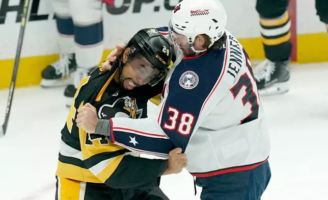 Pittsburgh Penguins' Mathew Dumba, left, fights Columbus Blue Jackets' Boone Jenner (38) during the first period of an NHL hockey game, Saturday, Oct. 25, 2025, in Pittsburgh. (AP Photo/Matt Freed)