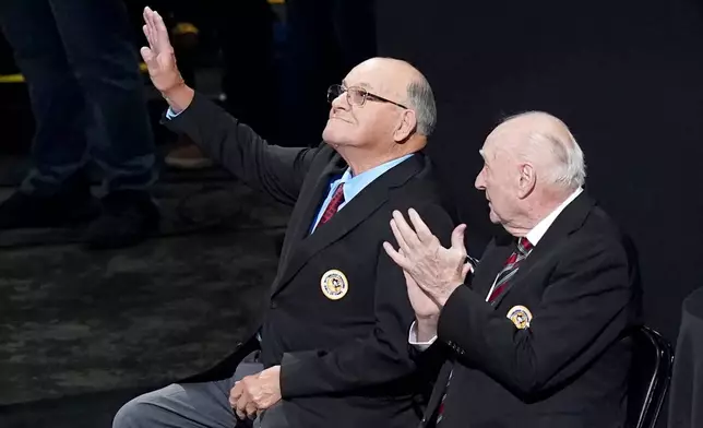 Former Pittsburgh Penguins head coach Scotty Bowman, left, waves next to former general manager and head coach Eddie Johnston as he's introduced during a ceremony inducting him into the 2025 Pittsburgh Penguins Hall of Fame class before an NHL hockey game between the Columbus Blue Jackets and the Pittsburgh Penguins, Saturday, Oct. 25, 2025, in Pittsburgh. (AP Photo/Matt Freed)