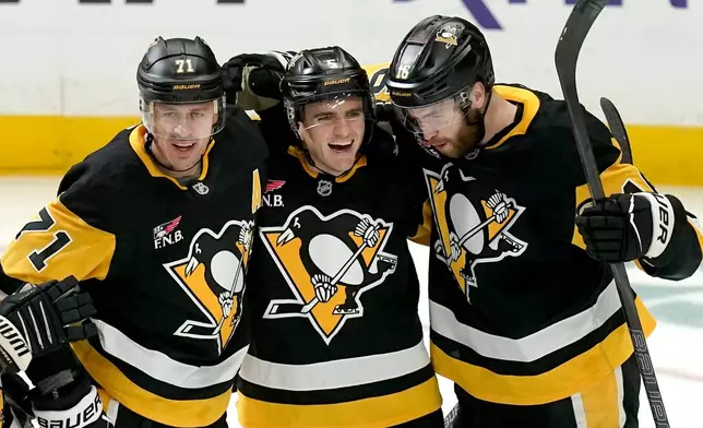 Pittsburgh Penguins' Ryan Shea (5) celebrates with Evgeni Malkin (71) and Justin Brazeau (16) after scoring during the first period of an NHL hockey game against the Columbus Blue Jackets, Saturday, Oct. 25, 2025, in Pittsburgh. (AP Photo/Matt Freed)