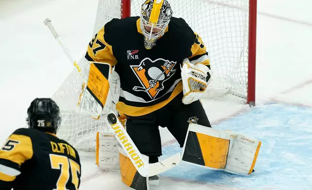Pittsburgh Penguins goaltender Arturs Silovs makes a save during the first period of an NHL hockey game against the Columbus Blue Jackets, Saturday, Oct. 25, 2025, in Pittsburgh. (AP Photo/Matt Freed)