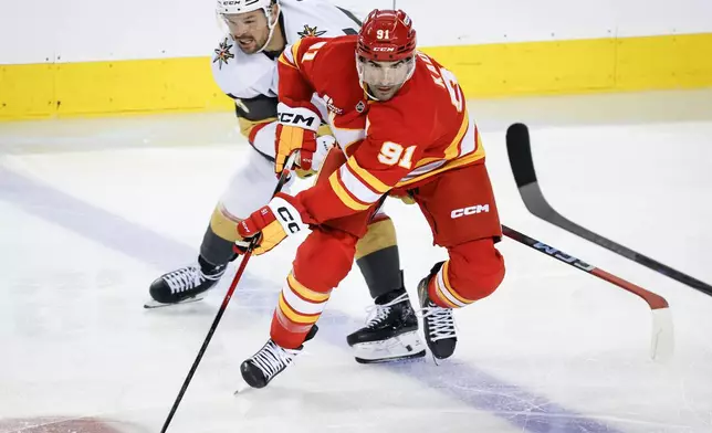 Vegas Golden Knights' Tomas Hertl, left, chases Calgary Flames' Nazem Kadri during third period NHL hockey action in Calgary on Tuesday, Oct. 14, 2025. (Jeff McIntosh/The Canadian Press via AP)