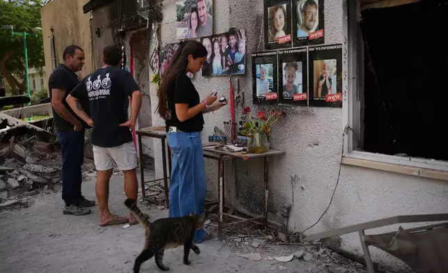 People visit the burnt house of Siman Tov family where all five family members were killed during the Hamas attack on Oct. 7, 2023, in Kibbutz Nir Oz, Israel, a day before Israel marks the two-year anniversary of the attack, Monday, Oct. 6, 2025. (AP Photo/Ohad Zwigenberg)