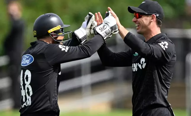 New Zealand's Tom Latham, left, celebrates with teammate Will Young after the dismissal of England's Harry Brook during their T20 cricket match in Hamilton, New Zealand, Wednesday, Oct. 29, 2025. (Andrew Cornaga/Photosport via AP)