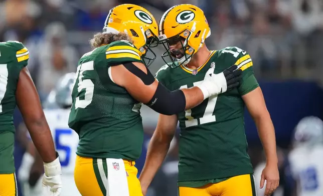 Green Bay Packers' Sean Rhyan (75) and Brandon McManus (17) celebrate after McManus kicked an extra point in the first half of an NFL football game against the Dallas Cowboys Sunday, Sept. 28, 2025, in Arlington, Texas. (AP Photo/Julio Cortez)