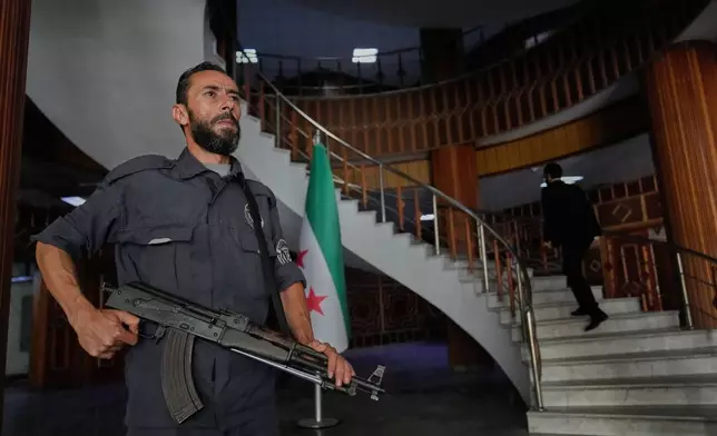 A Syrian policeman stands guard at Latakia's Governor building where the voting for a parliamentary election will take place, in the coastal city of Latakia, Syria, Sunday, Oct. 5, 2025. (AP Photo/Hussein Malla)