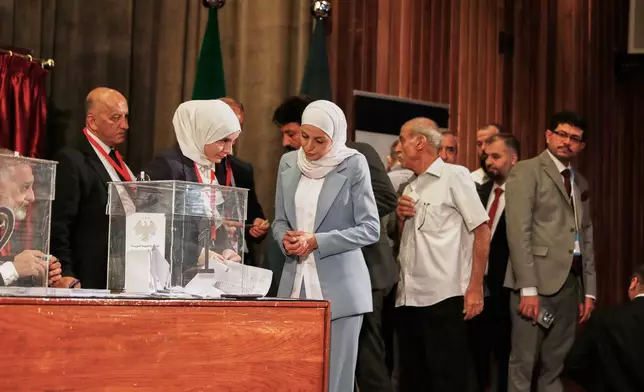 Syrian electoral college members line up to cast their ballots in a parliamentary election at a polling station in Damascus, Syria, Sunday, Oct. 5, 2025. (AP Photo/Omar Sanadiki)