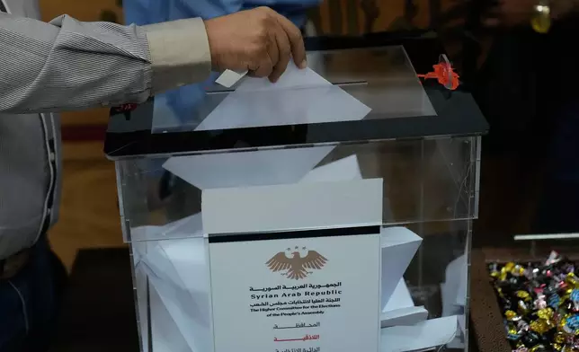 A Syrian electoral college member casts his vote during a parliamentary election at Latakia's Governor ballot station, in the coastal city of Latakia, Syria, Sunday, Oct. 5, 2025. (AP Photo/Hussein Malla)