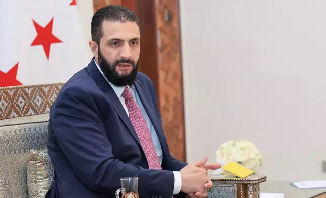 FILE - In this photo released by the Syrian official news agency SANA, Syria's interim President Ahmad al-Sharaa receives the final version of the provisional electoral system for the People's Assembly, in Damascus, Syria, Sunday, July 27, 2025. (SANA via AP, file)