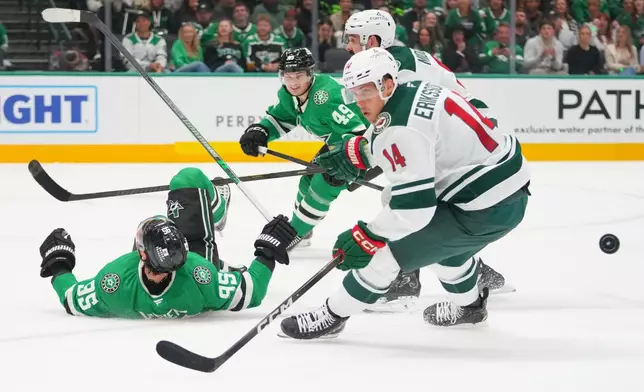 Dallas Stars center Matt Duchene (95) hits the ice while attacking against Minnesota Wild center Joel Eriksson Ek (14) and defenseman Jake Middleton, back right, during the first period of an NHL hockey game Tuesday, Oct. 14, 2025, in Dallas. (AP Photo/Julio Cortez)