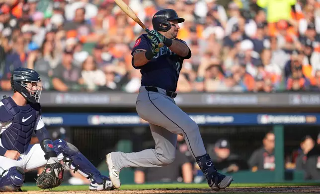 Seattle Mariners' Cal Raleigh follows through on an RBI single during the fifth inning in Game 4 of baseball's American League Division Series against the Detroit Tigers Wednesday, Oct. 8, 2025, in Detroit. (AP Photo/Paul Sancya)