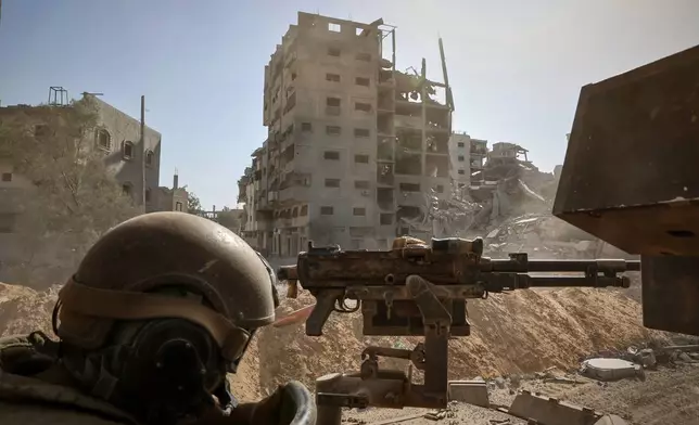 This picture taken during a media tour organised by the Israeli army shows an Israeli army soldier behind a mounted machine gun in the vicinity of the Jordanian Field Hospital in Gaza City, Friday, Oct. 3, 2025. (Jack Guez/Pool Photo via AP)