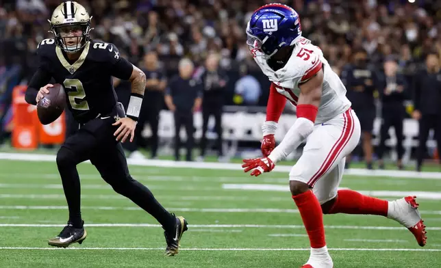 New Orleans Saints quarterback Spencer Rattler (2) runs against New York Giants linebacker Abdul Carter (51) in the second half of an NFL football game, Sunday, Oct. 5, 2025, in New Orleans. (AP Photo/Butch Dill)