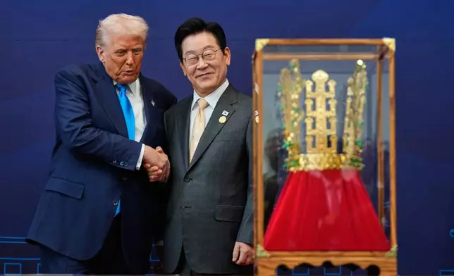 President Donald Trump shakes hands with South Korean President Lee Jae Myung as he receives a gift of a gold crown and an award of the Grand Order of Mugunghwa, not seen, during a high honor ceremony at the Gyeongju National Museum in Gyeongju, South Korea, Wednesday, Oct. 29, 2025. (AP Photo/Mark Schiefelbein)