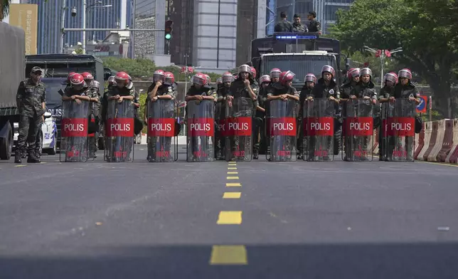 Federal Reserve Unit (FRU) police officers block a road during a demonstration against U.S. President Donald Trump's attendance at the Association of Southeast Asian Nations (ASEAN) Summit in Kuala Lumpur, Malaysia, on Sunday, Oct. 26, 2025. (AP Photo/Azneal Ishak)