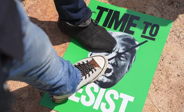 Protesters steps on a poster of U.S. President Donald Trump during a demonstration his attendance at the Association of Southeast Asian Nations (ASEAN) Summit in Kuala Lumpur, Malaysia, on Sunday, Oct. 26, 2025. (AP Photo/Azneal Ishak)