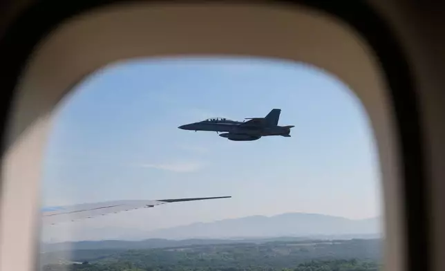A Malaysian Air Force jet escorts Air Force One into Kuala Lumpur International Airport in Sepang, Malaysia, Sunday, Oct. 26, 2025. (AP Photo/Mark Schiefelbein)