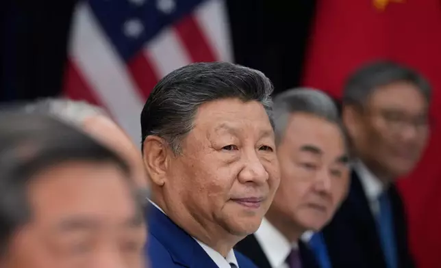 Chinese President Xi Jinping, center, meets with President Donald Trump, not in photo, at Gimhae International Airport in Busan, South Korea, Thursday, Oct. 30, 2025. Chinese Foreign Minister Wang Yi is at center right. (AP Photo/Mark Schiefelbein)