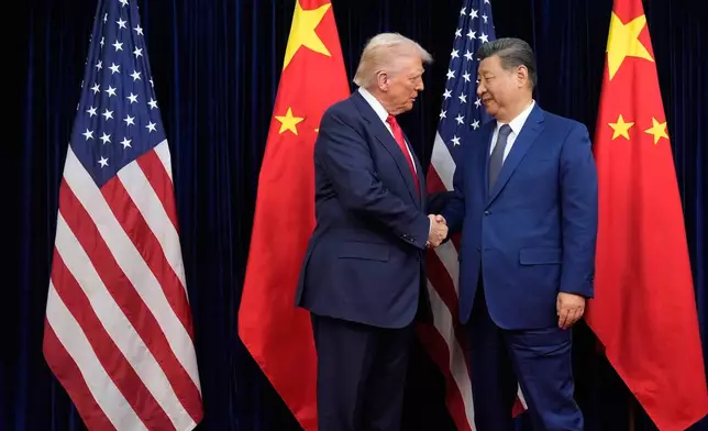 President Donald Trump, left, and Chinese President Xi Jinping shake hands before their meeting at Gimhae International Airport in Busan, South Korea, Thursday, Oct. 30, 2025. (AP Photo/Mark Schiefelbein)
