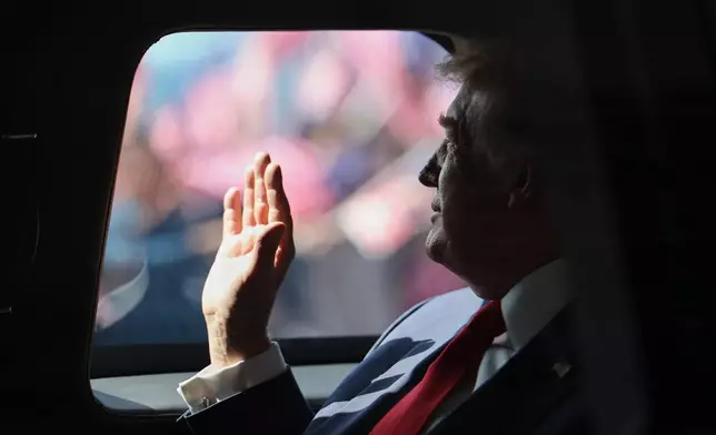 U.S. President Donald Trump waves from his official vehicle as he heads to attend the 47th Association of Southeast Asian Nations (ASEAN) summit after arriving at Kuala Lumpur International Airport in Kuala Lumpur, Malaysia, Sunday, Oct. 26, 2025. (Hasnoor Hussain/Pool Photo via AP)
