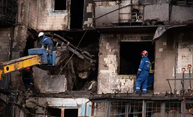 Firefighters work at a destroyed apartment building after a Russian drone attack in Kyiv, Ukraine, Sunday, Oct. 26, 2025. (AP Photo/Dan Bashakov)