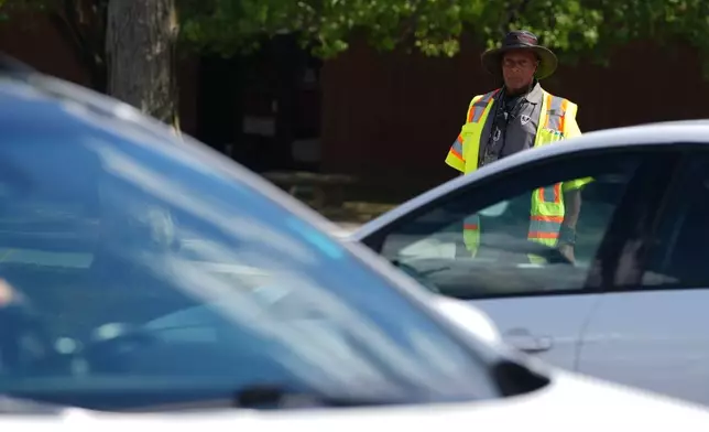 School crossing guard Anthony Taylor waits to cross the street, Wednesday, Sept. 3, 2025, in Indianapolis. (AP Photo/Darron Cummings)