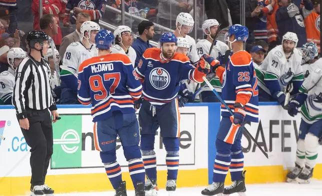Edmonton Oilers' Connor McDavid (97), Leon Draisaitl (29) and Darnell Nurse (25) celebrate a goal against the Vancouver Canucks the third period of an NHL game in Edmonton on Saturday, Oct. 11, 2025. (Jason Franson/The Canadian Press via AP)