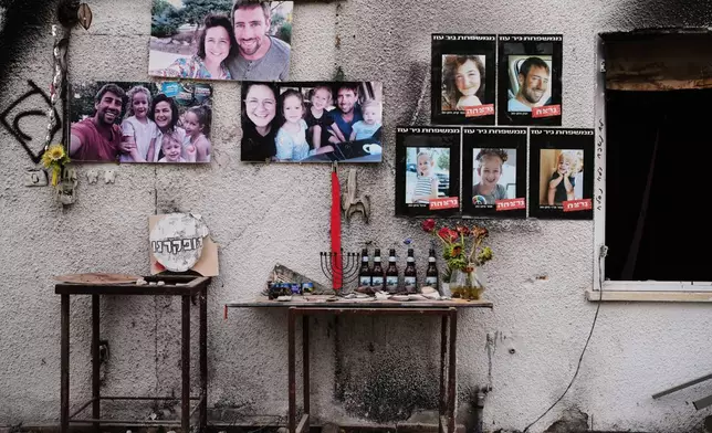 Photos of the Siman Tov family are plastered on their burnt house where all five of them were killed during the Hamas attack on Oct. 7, 2023, in Kibbutz Nir Oz, Israel, a day before Israel marks the two-year anniversary of the attack, Monday, Oct. 6, 2025. (AP Photo/Ohad Zwigenberg)