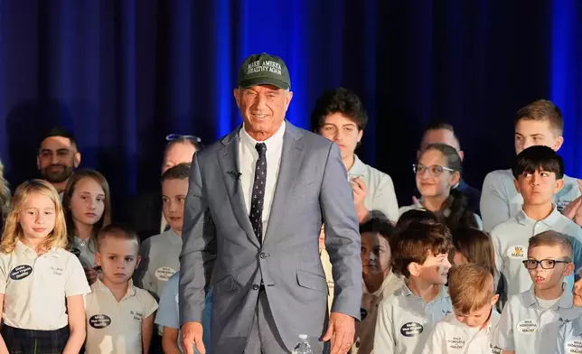 FILE - Health and Human Services Secretary Robert F. Kennedy Jr. stands among students during an event announcing proposed changes to SNAP and food dye legislation, Friday, March 28, 2025, in Martinsburg, W. Va. (AP Photo/Stephanie Scarbrough, File)
