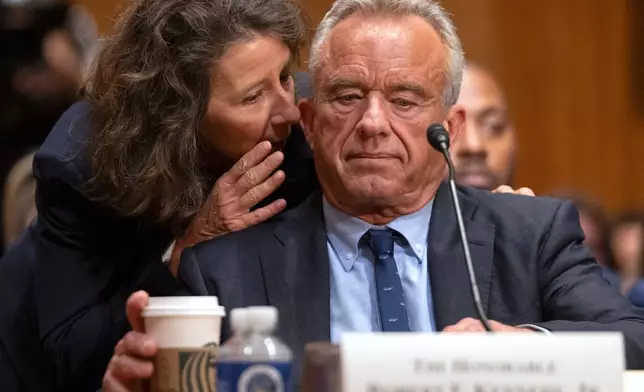 FILE - Secretary of Health and Human Services Robert F. Kennedy Jr. listens to deputy chief of staff Stefanie Spear speaks to him during a hearing the Senate Finance Committee, on Capitol Hill in Washington, Thursday, Sept. 4, 2025. (AP Photo/Mark Schiefelbein, File)