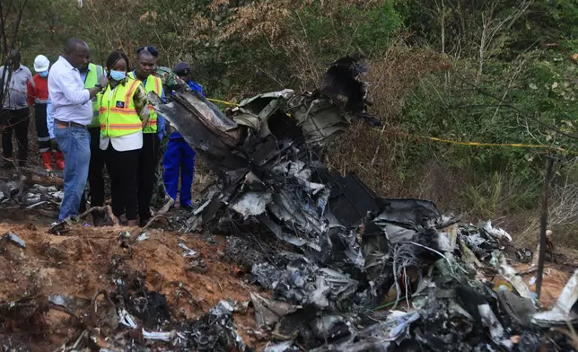Kenya Principal Secretary State Department for Aviation and Aerospace Development Teresia Mbaika, center, and other top government officials inspect at the scene of a plane crash Wednesday, Oct. 29, 2025, that killed 12 people near Diani, Kenya, (AP Photo/Andrew Kasuku)