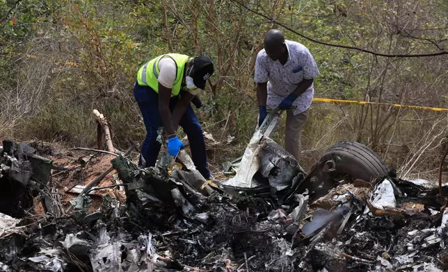 Directorate of Criminal Investigations and Aircraft Accident Investigators inspect the scene of a plane crash Wednesday, Oct. 29, 2025, that killed 12 people near Diani, Kenya, (AP Photo/Andrew Kasuku)