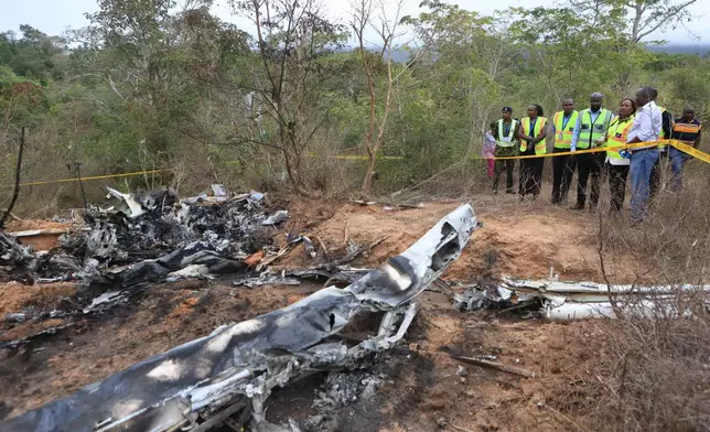 Kenya Principal Secretary State Department for Aviation and Aerospace Development Teresia Mbaika (second right) and other top government officials inspect Wednesday, Oct. 29, 2025 the scene of a plane crash that killed 12 people near Diani, Kenya, (AP Photo/Andrew Kasuku)