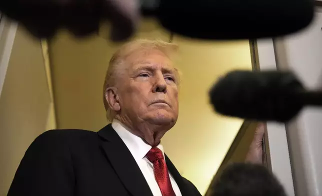 President Donald Trump speaks to reporters aboard Air Force One, Sunday, Oct. 19, 2025, en route to Joint Base Andrews, Md., as he returns from a trip to Florida. (AP Photo/Mark Schiefelbein)