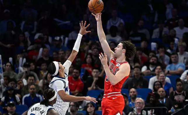 Chicago Bulls guard Josh Giddey, right, shoots in front of Orlando Magic guard Anthony Black and center Wendell Carter Jr. (34) during the second half of an NBA basketball game, Saturday, Oct. 25, 2025, in Orlando, Fla. (AP Photo/Phelan M. Ebenhack)