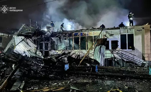 In this photo provided by the Ukrainian Emergency Service, emergency services personnel work to extinguish a fire following a Russian attack in Brovary, near Kyiv, Ukraine, Friday, Oct. 10, 2025. (Ukrainian Emergency Service via AP)
