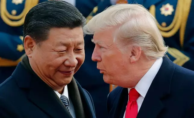 FILE - In this Nov. 9, 2017, file photo, U.S. President Donald Trump, right, chats with Chinese President Xi Jinping during a welcome ceremony at the Great Hall of the People in Beijing. (AP Photo/Andy Wong, File)