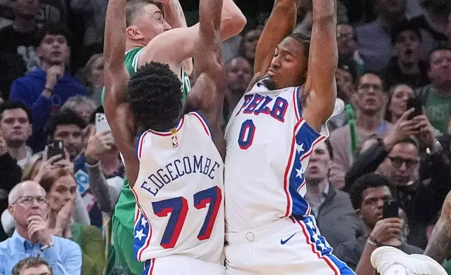 Philadelphia 76ers guard Tyrese Maxey (0) and guard VJ Edgecombe (77) pressure Boston Celtics guard Payton Pritchard (11), who was making a failed attempt at the game-winning basket, during the final seconds of the second half of an NBA basketball game, Wednesday, Oct. 22, 2025, in Boston. (AP Photo/Charles Krupa)