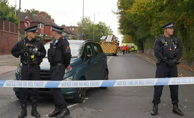 Police stand guard near the scene of a stabbing incident at Heaton Park Hebrew Congregation synagogue, in Crumpsall, Manchester, England, Thursday, Oct. 2, 2025. (AP Photo/Ian Hodgson)
