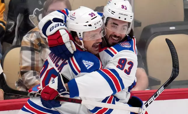 New York Rangers' Mika Zibanejad (93) celebrates his goal with Sam Carrick during the first period of an NHL hockey game against the Pittsburgh Penguins in Pittsburgh, Saturday, Oct. 11, 2025. (AP Photo/Gene J. Puskar)