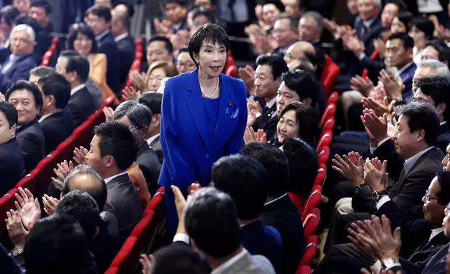 Former Economic Security Minister Sanae Takaichi, center, stands as Takaichi was chosen to a new leader of Japan’s ruling Liberal Democratic Party during the party's leadership election in Tokyo, Japan, Saturday, Oct. 4, 2025. (Kyodo News via AP)