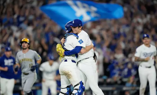 Los Angeles Dodgers pitcher Roki Sasaki and catcher Will Smith celebrates their win against the Milwaukee Brewers in Game 4 of baseball's National League Championship Series, Friday, Oct. 17, 2025, in Los Angeles. (AP Photo/Brynn Anderson)