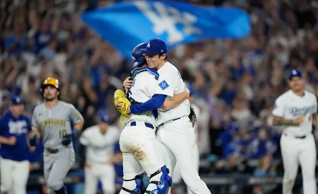 Los Angeles Dodgers pitcher Roki Sasaki and catcher Will Smith celebrates their win against the Milwaukee Brewers in Game 4 of baseball's National League Championship Series, Friday, Oct. 17, 2025, in Los Angeles. (AP Photo/Brynn Anderson)