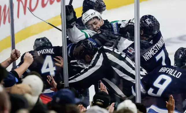 Winnipeg Jets' Vladislav Namestnikov (7) hits Dallas Stars' Jason Robertson (21) in a scuffle against the boards during second-period NHL hockey game action in Winnipeg, Manitoba, Thursday, Oct. 9, 2025. (John Woods/The Canadian Press via AP)