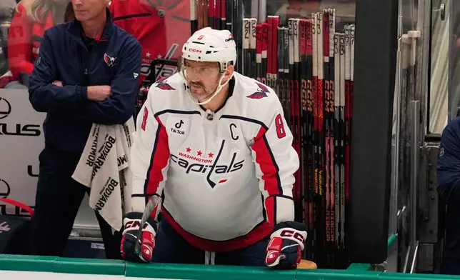 Washington Capitals left wing Alex Ovechkin watches play from the bench in the first period of an NHL hockey game against the Dallas Stars Tuesday, Oct. 28, 2025, in Dallas. (AP Photo/Tony Gutierrez)