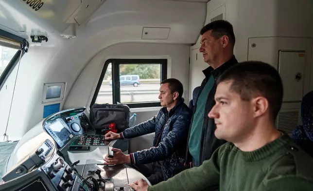 Oleh Pryshchepa, 54, second right, a train driver, rides at the train driver's cabin in Kyiv, Ukraine, Friday, Oct. 3, 2025. (AP Photo/Vasilisa Stepanenko)