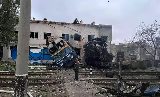 In this photo provided by Office of the Deputy Prime Minister for Restoration and Development on Thursday, Oct. 2, 2025, a railway worker stands in front of a train locomotive destroyed by a Russian strike in Odesa, Ukraine. (Office of the Deputy Prime Minister for Restoration and Development via AP)