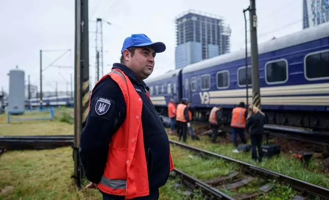 Shevcuk Maksym, 30, a railway repair team leader, looks at railway track repair work in Kyiv, Ukraine, Thursday, Oct. 2, 2025. (AP Photo/Evgeniy Maloletka)